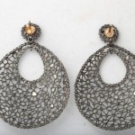 A pair of earrings with large silver and yellow stones.
