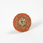 A red and gold ring with a star design.