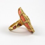 A gold ring with an orange and red design on it.
