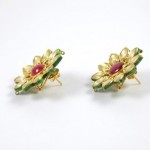 A pair of earrings with green and red enamel.