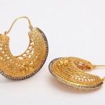 A pair of gold earrings with intricate designs.