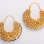 A pair of gold and silver earrings with flowers.
