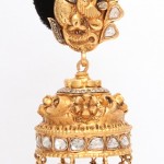 A gold and diamond earring with an elephant head.