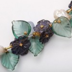 A close up of the leaves and flowers on a necklace