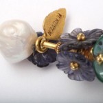 A close up of the pearl and flower earrings