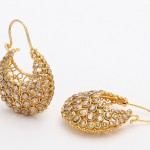 A pair of gold earrings with white stones.