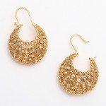 A pair of gold earrings with clear stones.