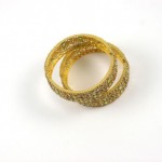 A pair of gold bangles sitting on top of each other.