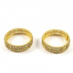 A pair of gold bangles with green stones.