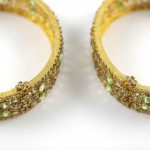 A pair of yellow and green bracelets with gold trim.