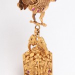 A gold statue of a horse and rider on top of a box.