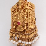 A gold and pearl pendant with an eagle design.