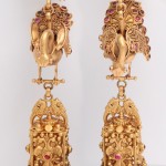 A pair of gold earrings with peacock design.