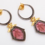 A pair of earrings with pink stones and gold accents.