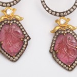 A pair of earrings with pink stones and gold accents.