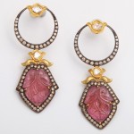 A pair of earrings with pink stones and gold accents.