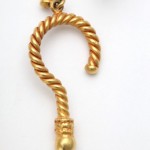 A gold earring with a twisted design on it.