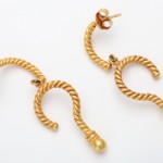 A pair of gold earrings with twisted wire design.