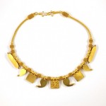 A gold necklace with various shapes and sizes.