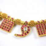 A close up of a necklace with red stones