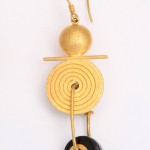 A pair of earrings with gold and black circles.