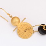 A pair of earrings with gold and black beads.