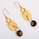 A pair of gold earrings with black beads.