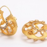 A pair of gold earrings with diamonds on them.