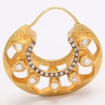 A gold hoop earring with white stones on it.
