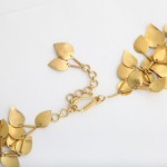 A close up of the gold chain with leaves