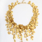 A gold necklace with leaves hanging down.
