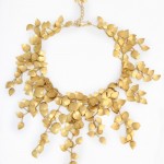 A gold necklace with leaves hanging down.