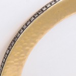 A close up of the bottom of a gold bracelet