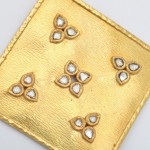 A gold square with five small white stones.