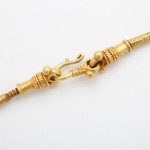 A close up of the gold clasp on a necklace