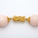 A close up of the gold bead on the necklace