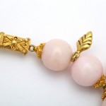 A close up of the gold leaf and pink beads