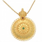 A gold necklace with a round pendant and green stone.